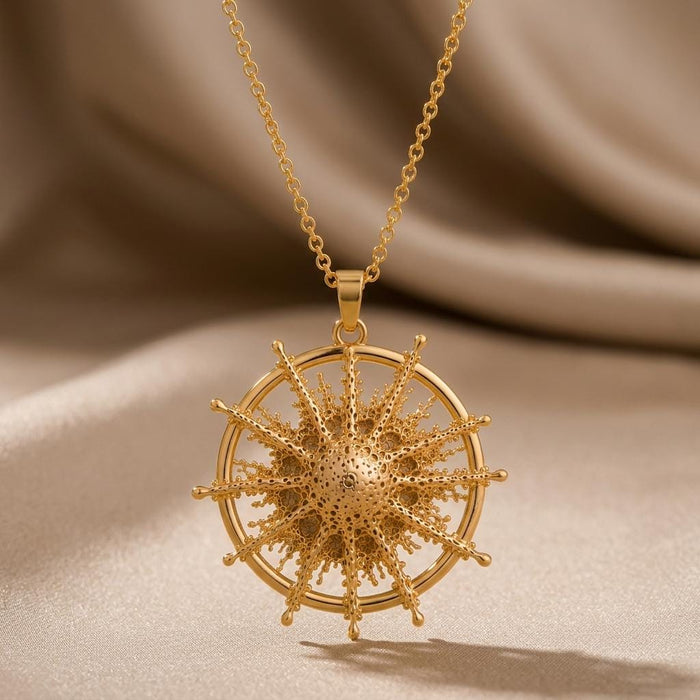 Achernar Star Pendant Necklace in Gold Plated Silver with a textured radial starburst on beige draped fabric