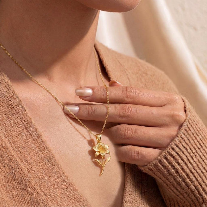 Close-up of a model holding the Gold Plated Silver Alstroemeria flower pendant necklace