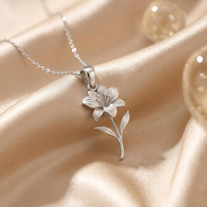 Silver Alstroemeria flower pendant necklace on champagne satin with glass props