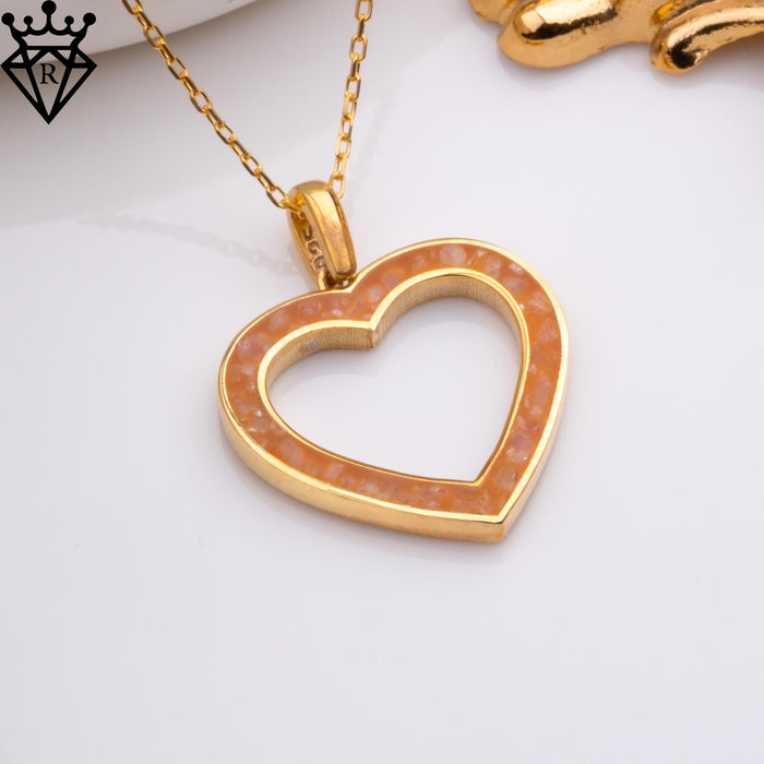 Close-up product photograph of an amber-colored open heart pendant on a white surface