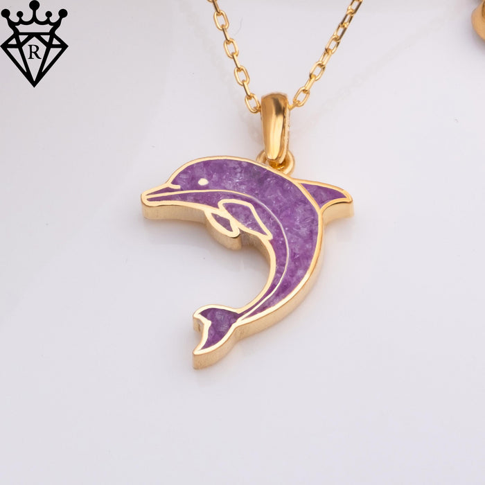 Close-up of the purple amethyst dolphin pendant with raised tail on a white surface