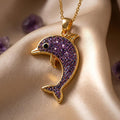 Gold Plated Silver Amethyst Druzy Dolphin Necklace with textured purple dolphin body on champagne fabric