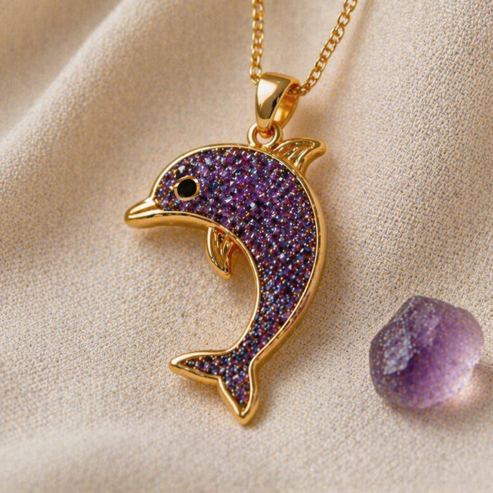 Gold Plated Silver dolphin pendant with textured purple body and dark eye beside a purple stone