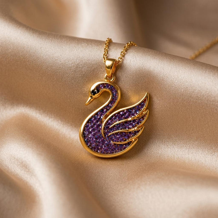 Close view of the Amethyst Druzy Swan Pendant Necklace on champagne satin showing the textured purple body and wing