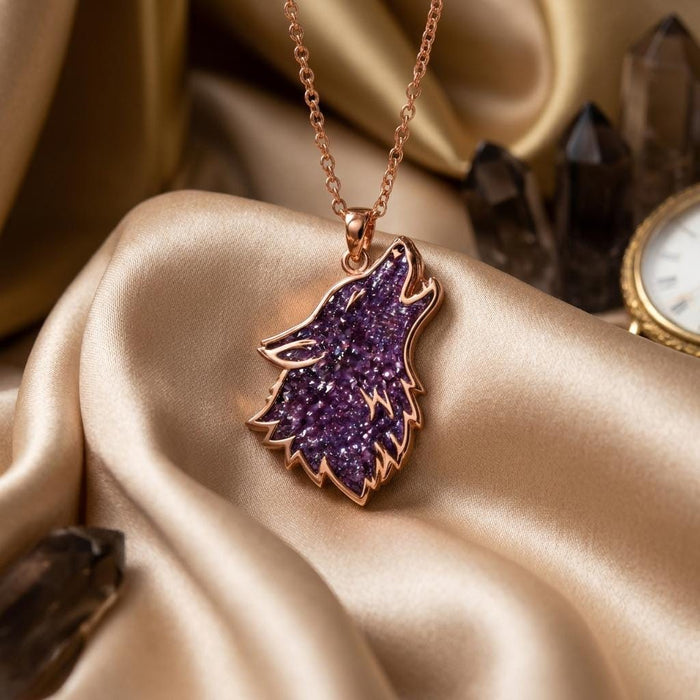 Rose Gold Plated Amethyst Druzy Wolf Necklace on champagne satin beside dark crystals and a watch