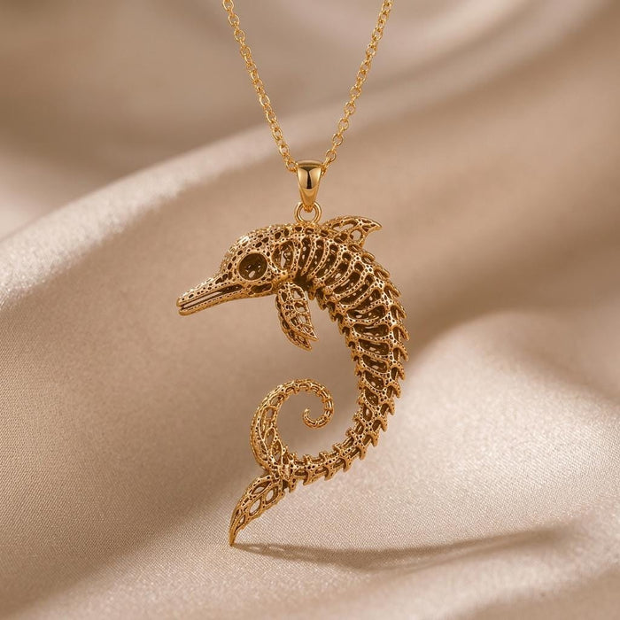 Gold Plated Silver Ancient Dolphin Fossil Necklace with a curled skeletal dolphin pendant on champagne satin