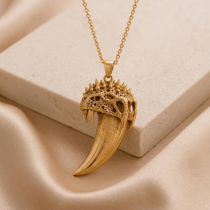 Gold Plated Silver Ancient Saber Tooth Pendant beside a pale stone block and satin
