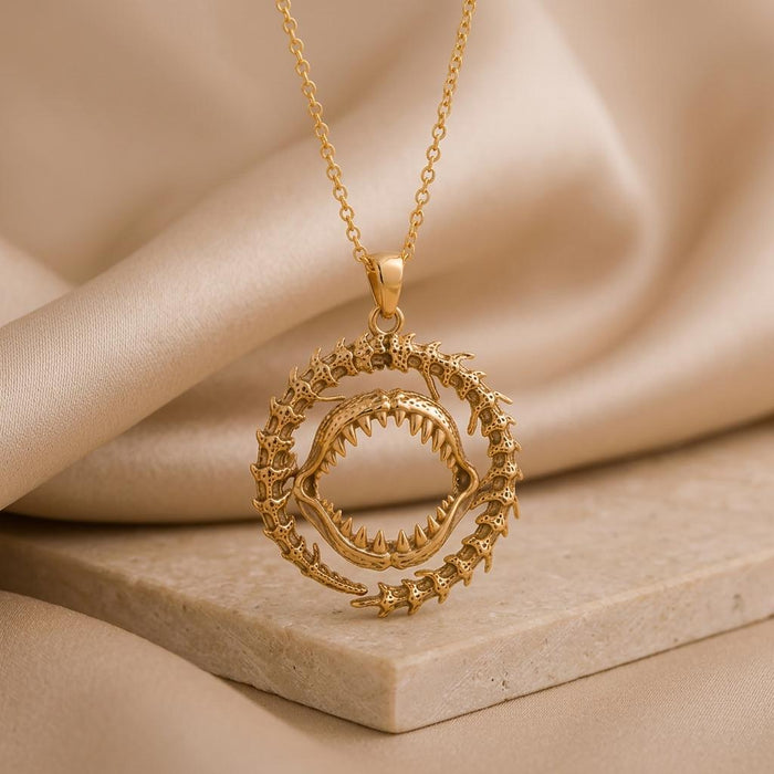 Close view of a Gold Plated Silver shark jaw pendant with pointed teeth and a circular fossil-inspired outer ring