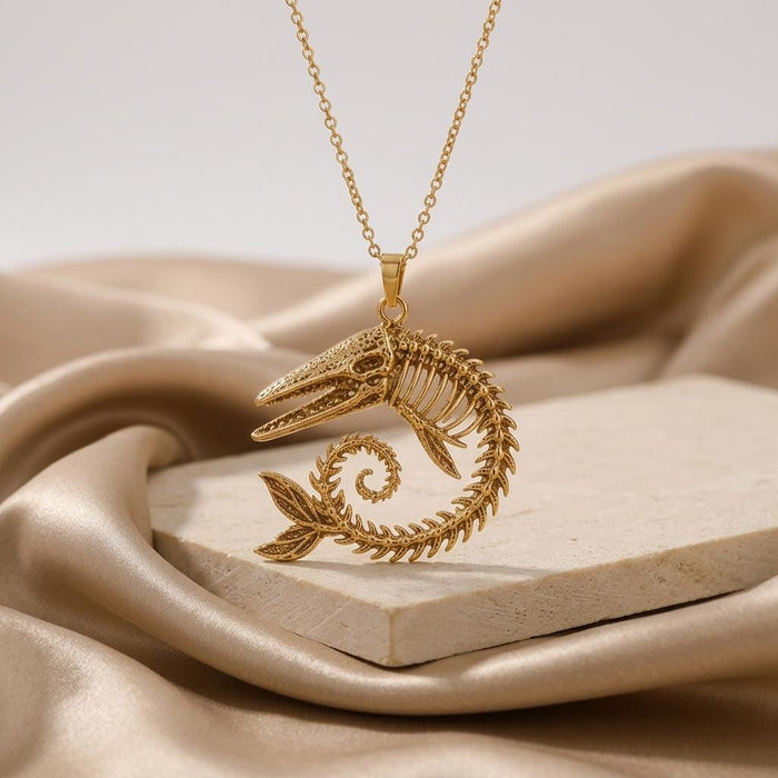Gold Plated Silver skeletal whale fossil pendant on a stone display with champagne satin