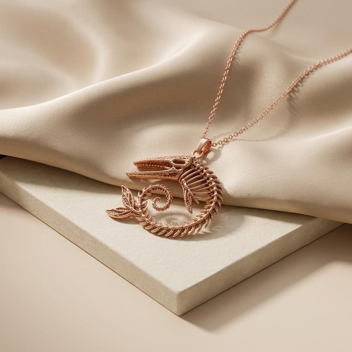 Rose Gold Plated Ancient Whale Fossil Pendant Necklace on cream fabric and a stone display
