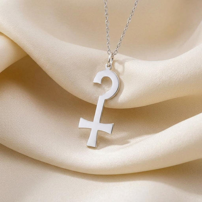 Close view of the Anubis Necklace looped pendant on cream satin fabric