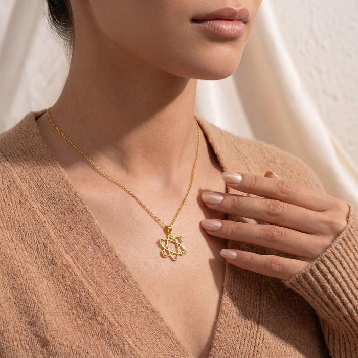 Gold Plated Silver Atom Necklace worn with a hand positioned near the pendant