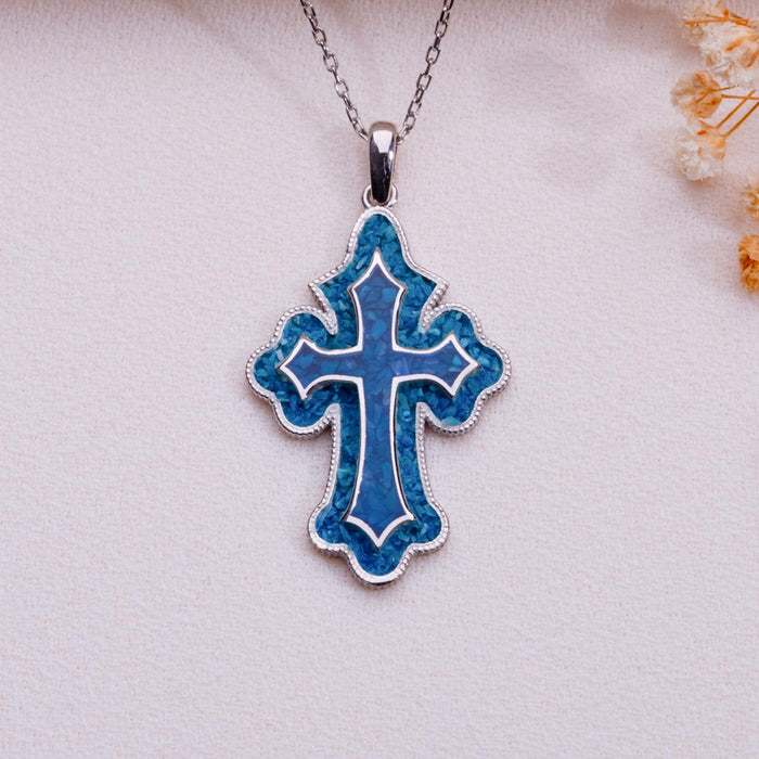 Blue Azurite inlay cross pendant necklace with raised inner cross outline on pale fabric