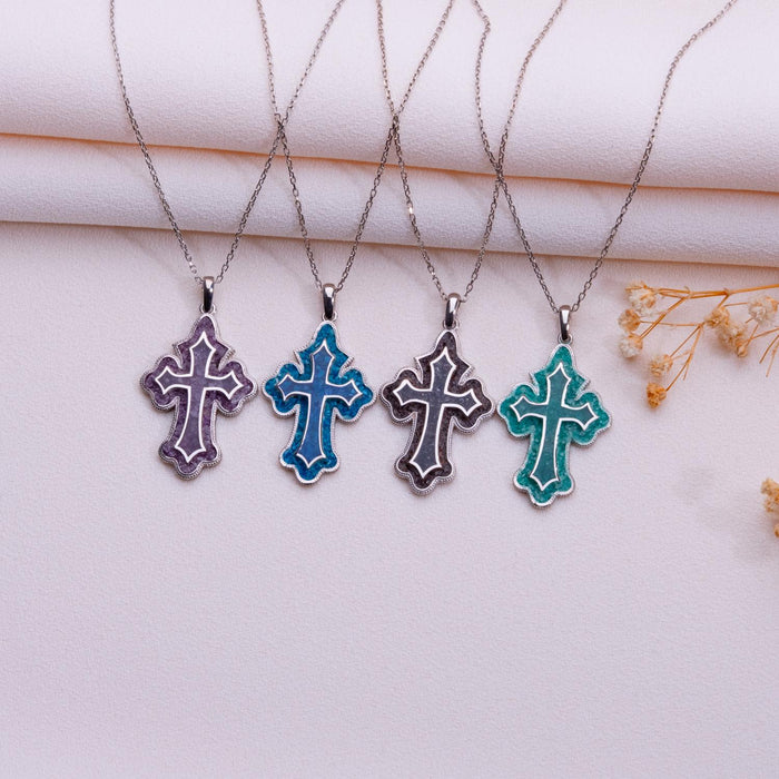 Four scalloped cross pendant necklaces in blue, purple, dark, and green colorways