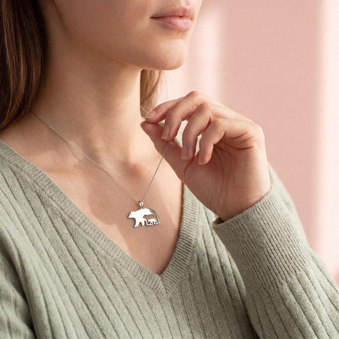 Side view of model wearing the Bear and Cub Necklace with a ribbed green sweater