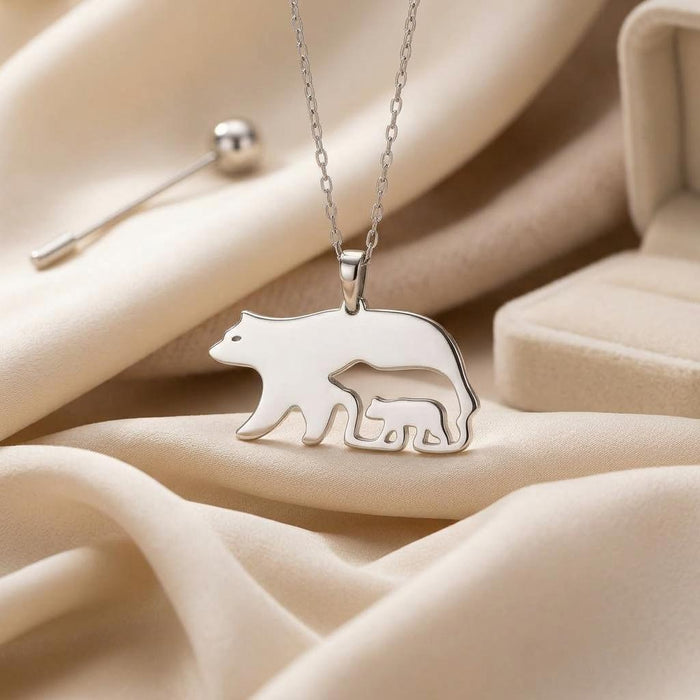 Close-up of connected bear and cub pendant on cream fabric