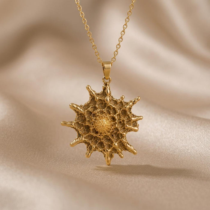 Gold Plated Silver Betelgeuse star pendant with textured center on draped beige fabric