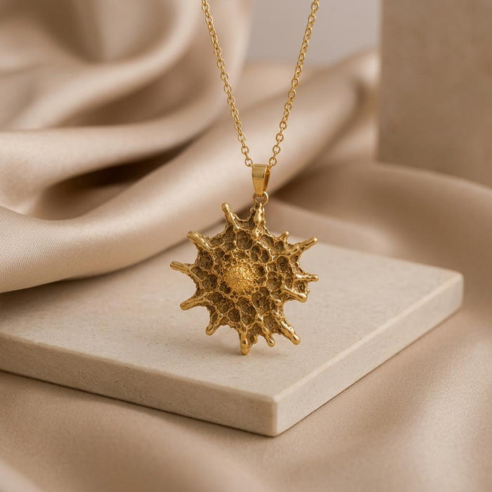 Gold Plated Silver textured Betelgeuse starburst pendant on a rectangular stone slab
