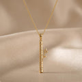 Gold Plated Silver Birch Veil Pendant Necklace with a segmented birch-inspired bar and leafy side branch on beige fabric