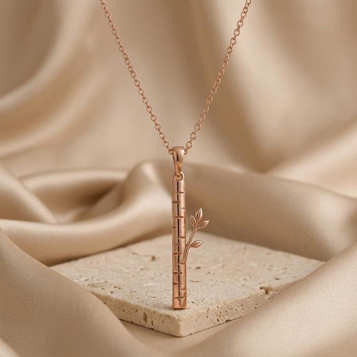 Rose Gold Plated Birch Veil Pendant Necklace displayed upright on a pale stone surface