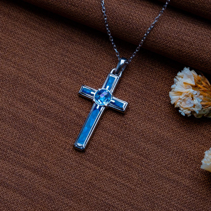 Blue Agate Cross Necklace on brown textured fabric with dried flowers