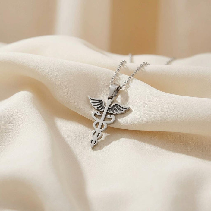 Silver Caduceus Necklace with winged staff and paired serpents on ivory satin