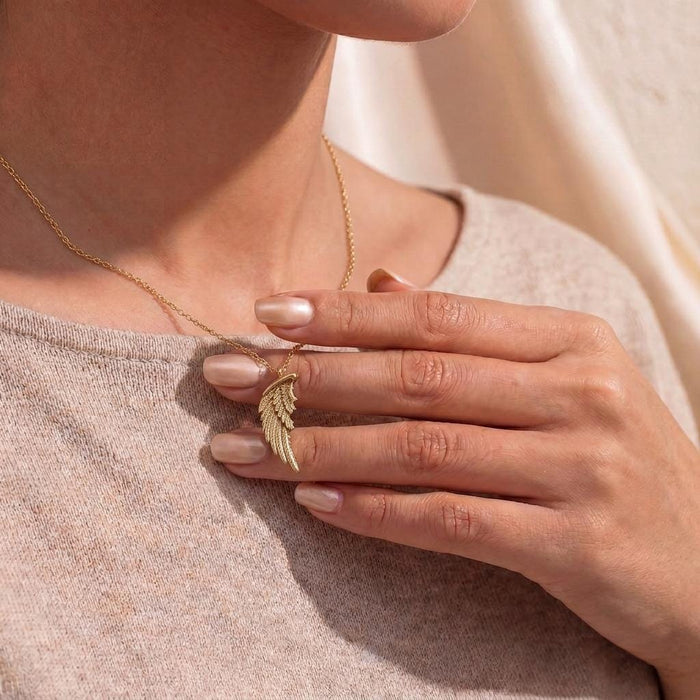 Gold Plated Silver Broken Wing Necklace worn with a light neutral knit top