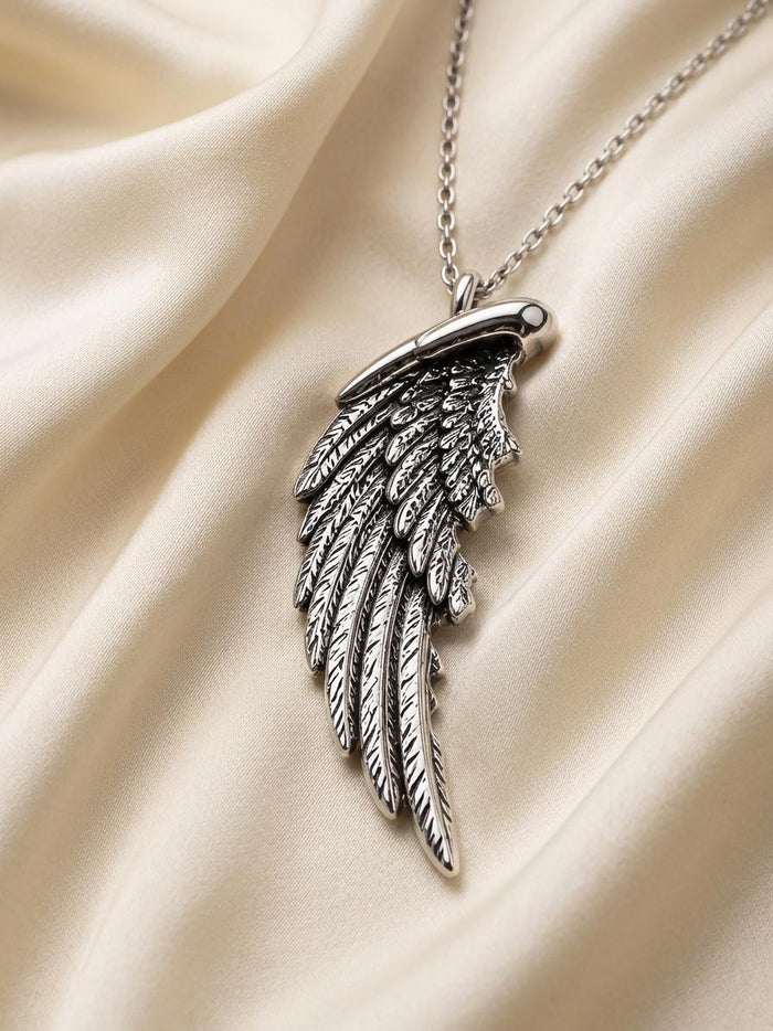 Silver Broken Wing Necklace with overlapping engraved feather details on ivory satin