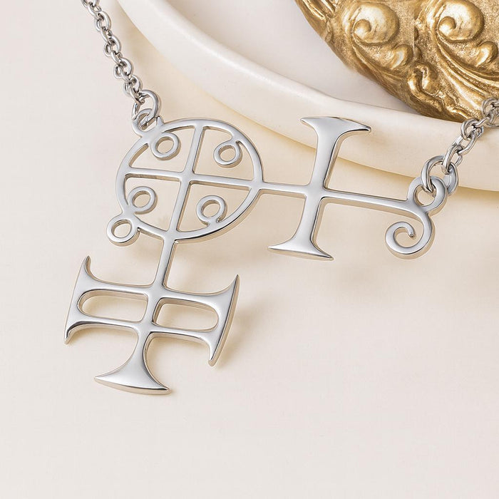 Silver Buer seal pendant close-up with divided circular section, curled terminals, and lower cross-like form