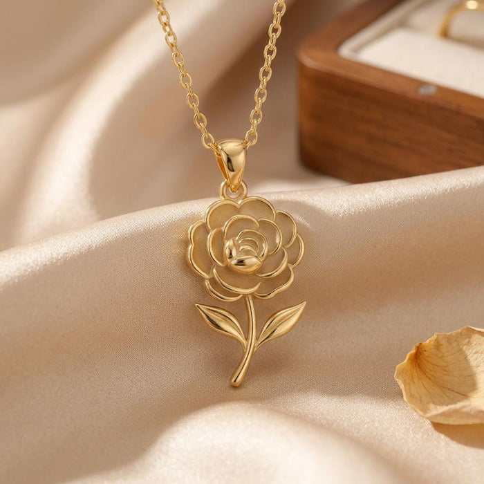Close-up of Gold Plated Silver Camellia Flower Necklace with a raised center, curved stem, and two leaves