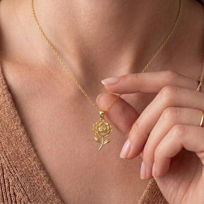 Hand adjusting a Gold Plated Silver Camellia Flower Necklace at the neckline