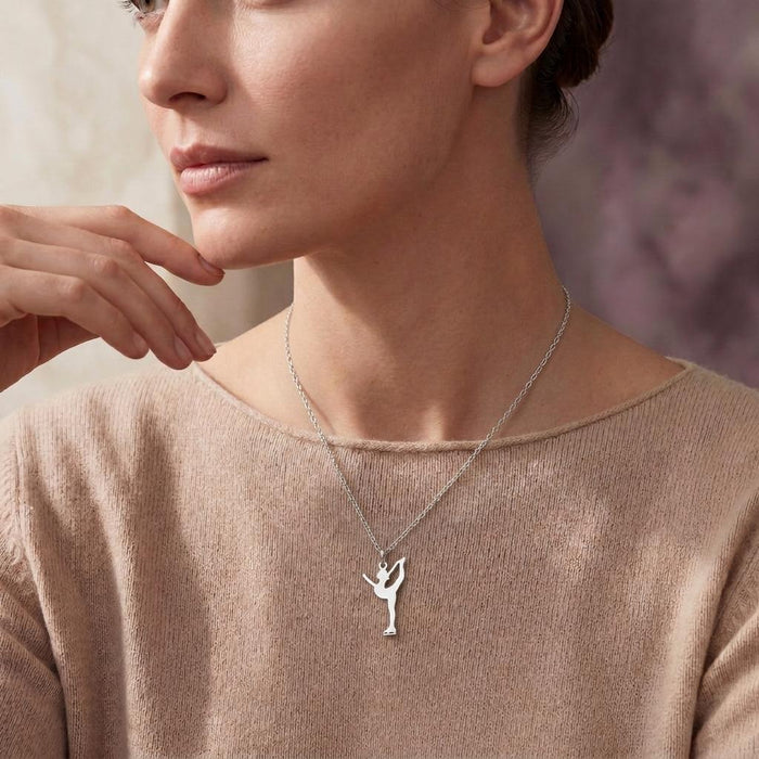 Silver catch-foot Figure Skater Necklace layered with a fine chain over a taupe sweater