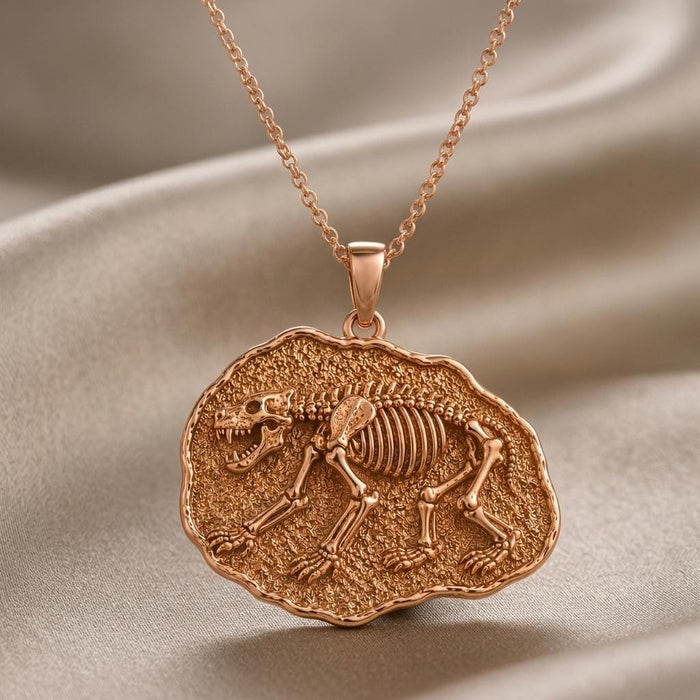 Close view of the raised skull, ribs and limbs on a rose-finish bear medallion against gray satin