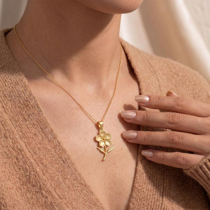 Gold Plated Silver Cherry Blossom Pendant Necklace worn on a model with a beige V-neck sweater