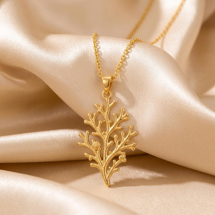 Gold Plated Silver Coral Branch Pendant Necklace displayed on champagne satin