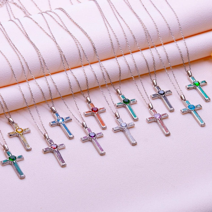 Multiple coral cross necklaces arranged in rows with varied round center stone colors