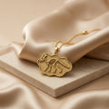 Gold Plated Silver Corythosaurus fossil pendant necklace on champagne satin and a pale stone slab