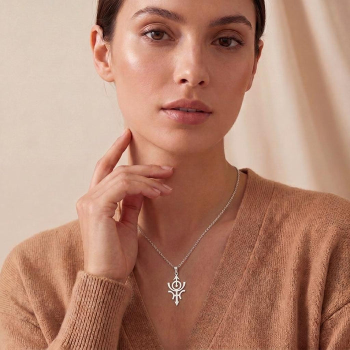 Front view of a model wearing the Cosmic Nibiru Necklace with a brown cardigan