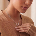 Silver Crescent Moon Necklace with three teardrop dangles worn with a beige knit top
