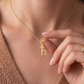 Gold Plated Silver Saturn Symbol Necklace worn close to the neckline