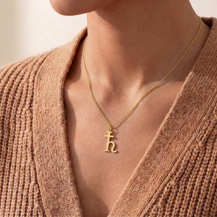 Gold Plated Silver Saturn Symbol Necklace worn with a knit cardigan