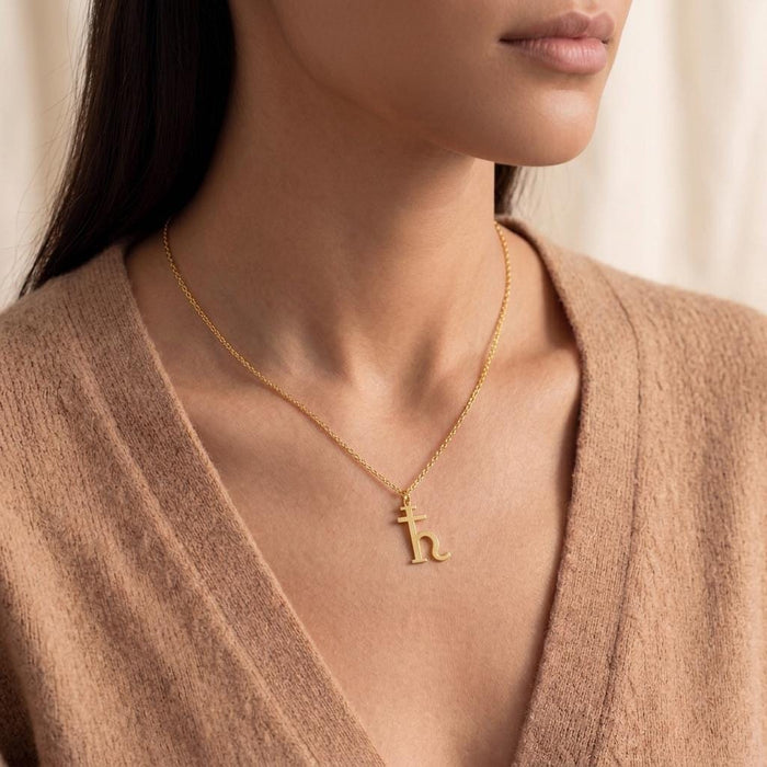 Gold Plated Silver Saturn glyph necklace shown at the collarbone