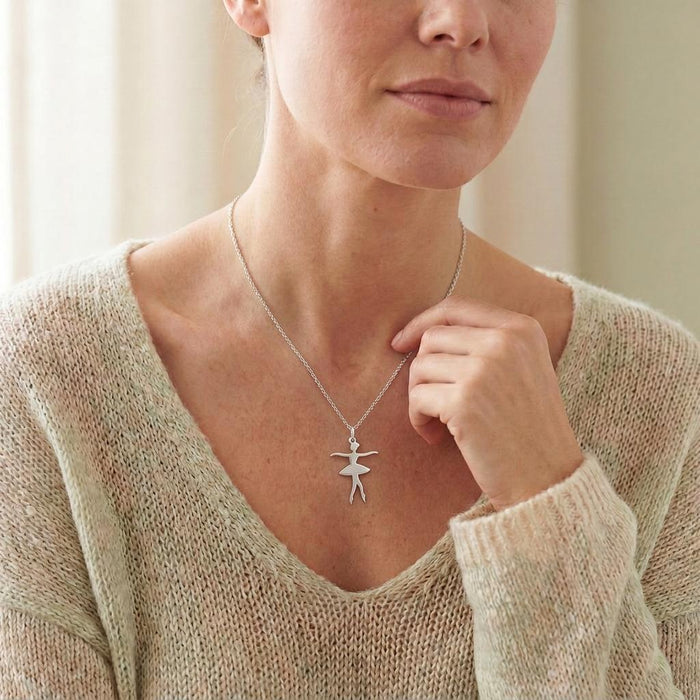 Crossed-feet Ballet Dancer Necklace worn with a cream knit V-neck sweater