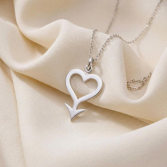 Close-up of the 925 sterling silver Cupido Symbol Necklace with an open heart and arrow silhouette