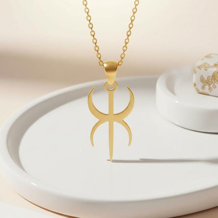 Gold Plated Silver Duality Symbol pendant above a white ceramic tray, showing the tapered bail and central pointed bar