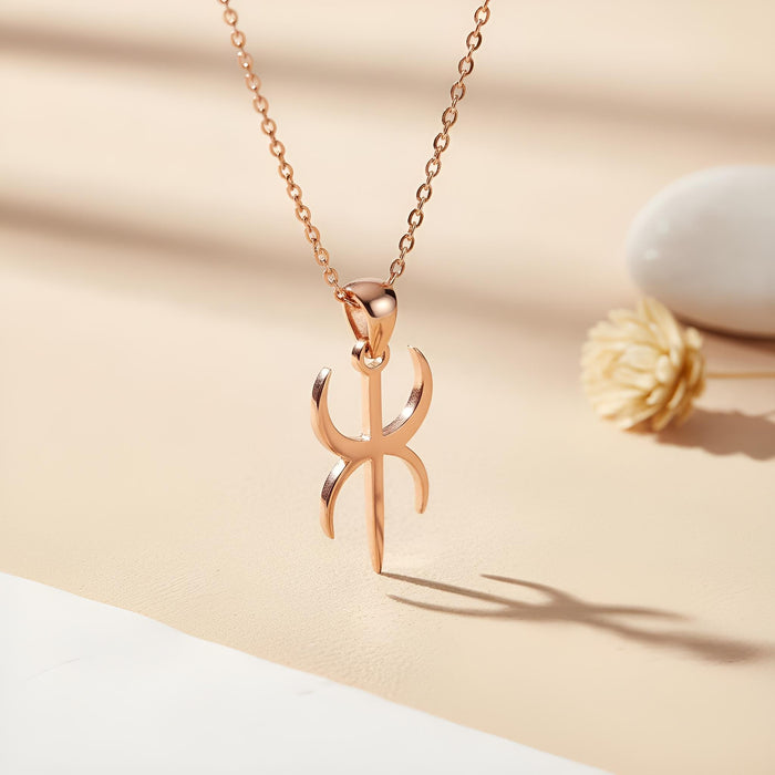 Rose Gold Plated Duality Symbol pendant necklace on a cream surface beside a dried flower