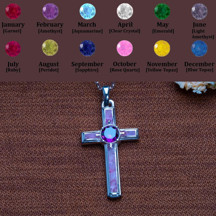 Birthstone personalization chart above a dainty amethyst cross necklace on brown textured fabric