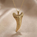Gold Plated Silver Dakosaurus tooth pendant necklace with textured upper section on champagne satin