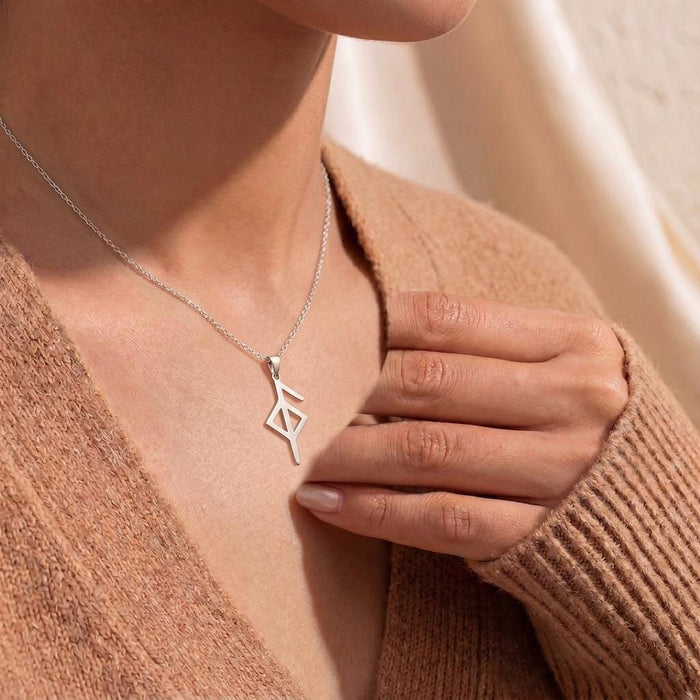 Silver Health Rune Necklace worn at the neckline with a brown knit cardigan