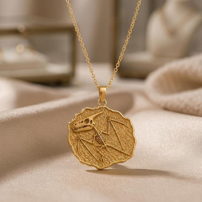 Gold Plated Silver Dimorphodon Fossil Pendant with a raised winged skeleton relief on a textured scalloped medallion